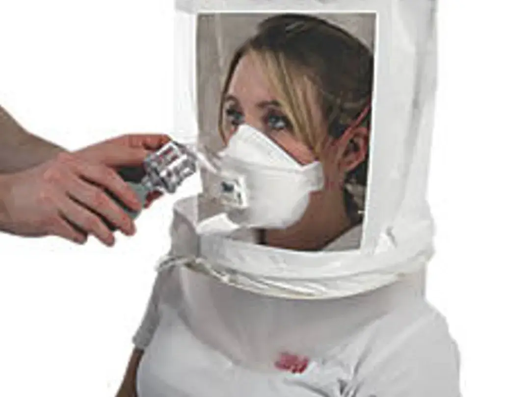 Worker wearing a test hood during a qualitative respirator fit test